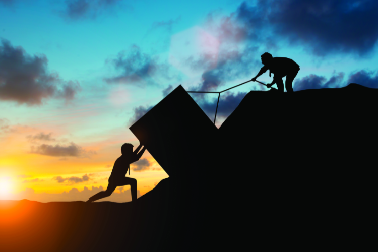 Two people lifting a rock together